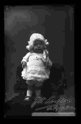 Foto de estudio de una bebe parada encima de un sillón