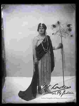 Foto de estudio de señora, luciendo un vestido noche con cetro de plumas.