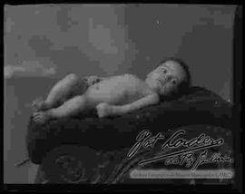 Foto de estudio de un bebe desnudo y recostado