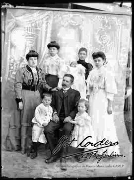 Foto de estudio de una familia en el patio de una casa particular con fondo de tela