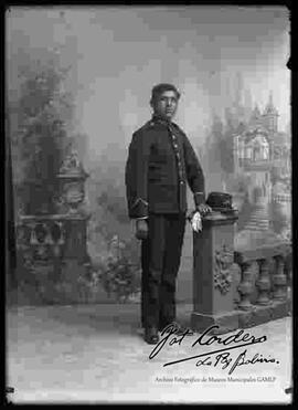 Foto de estudio de un soldado con uniforme francés que se encuentra  parado junto a la columna de un barandal