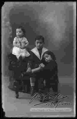 Foto de estudio de tres niños. Dos niñas y un niño