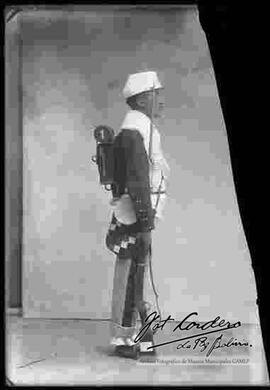 Foto de estudio de un Soldado de los Colorados de Bolivia, de perfil, con una chuspa con los colores de la wipala