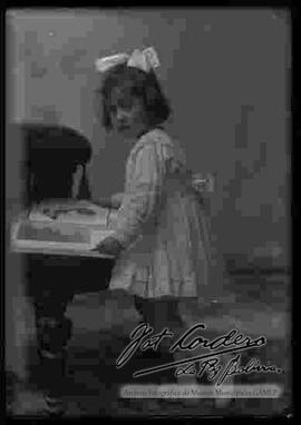 Foto de estudio de una niña, observando una revista