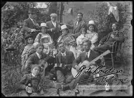 Familia, con conjunto musical de estudiantina en el huerto de una casa