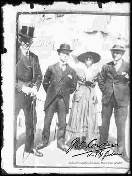 Reproducción de la imagen de una dama junto a tres varones, en el paseo del Prado. Presentan cuatro tipos de sombrero.