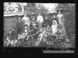 Familia reunida, en el huerto de una casa, festejando con música