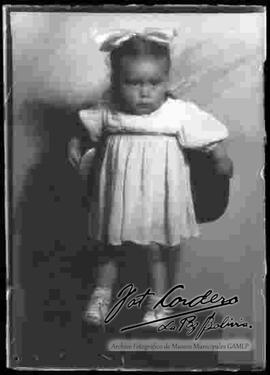 Foto de estudio de una niña pequeña, parada encima de una silla