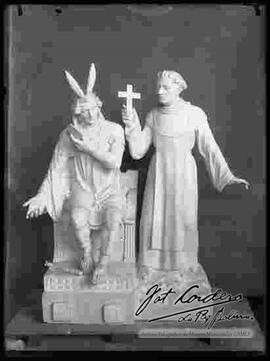 Maqueta de un cura enseñando la biblia a un inca.