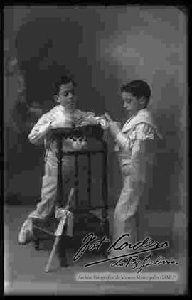 Foto de estudio de dos niños con ropa de primera comunión