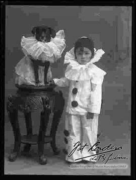 Foto de estudio de un niño junto a su perrito, vestidos de payaso.