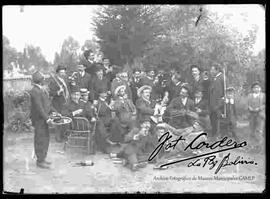 Grupo de varones (amigos), celebrando un acontecimiento con música y bebidas en el patio de una casa particular