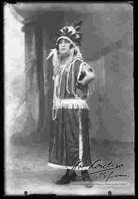 Foto de estudio de una señorita, luciendo un traje típico originario de india norte americana.