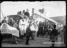 Comparsa de la "Sociedad Aguas Mudas" con su conjunto musical en camioncitos por la calle