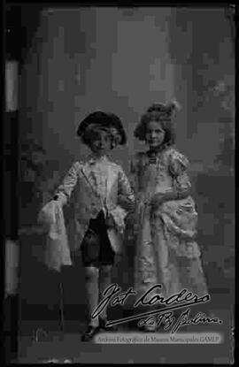 Foto de estudio de dos niños. Un niño y niña con trajes antiguos