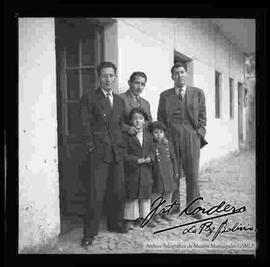 Miguel Alandia Pantoja junto a su hermano Edmundo Alandia que sostiene a sus dos hijos y un familiar, en el patio de su casa.