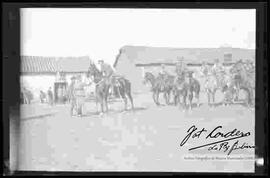 Hans Kunt montado a caballo, recibiendo saludo por parte de soldados en una población