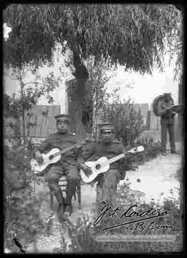 Dos soldados tocando guitarras en el patio del cuartel