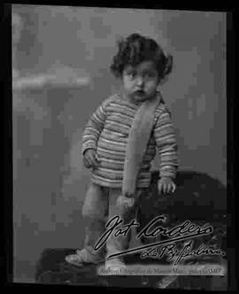 Foto de estudio de una niña que se encuentra parada encima de un sillón.