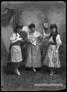 Foto de estudio de tres damas que llevan puesto, vestidos largos.