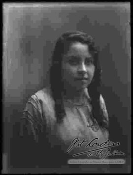 Fotografía de estudio de una señorita que presenta un modelo de peinado.