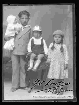 Foto de estudio de tres niños. Dos niños y un bebe (hermanitos).