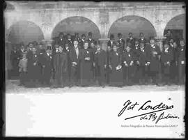 Curas junto a un grupo de varones en el patio de un Colegio