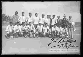 Equipo de futbol junto a sus dirigentes, en el campo de juego