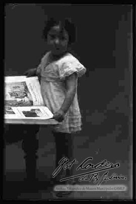 Foto de estudio de una niña mostrando un libro