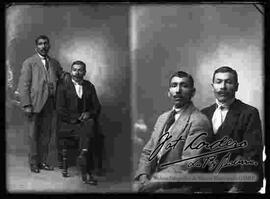 Foto de estudio de dos varones de bigote y vestidos de traje. Uno se encuentra parado y el otro sentado en un sillón