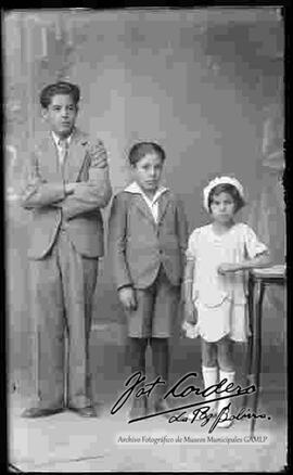 Foto de estudio de tres niños (hermanos). Dos niños y una niña