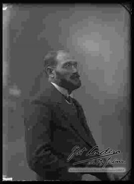 Fotografía de estudio. Imagen de medio cuerpo de un varón de perfil y von bigote.