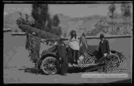 Familia, junto a un automóvil adornado. posiblemente por la zona de san jorge