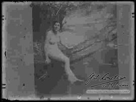 Reproducción del cuadro de una mujer desnuda, sentada en el tronco de un árbol a orillas de un río.