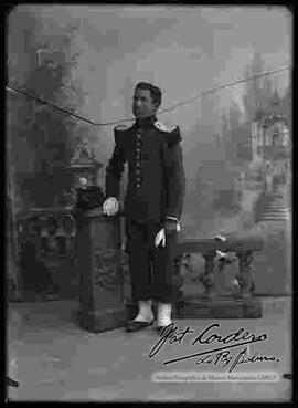 Foto de estudio de un soldado, parado y apoyado a una pequeña columna