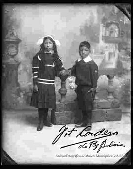 Foto de estudio de dos niños. Un niño y una niña, parados junto a una baranda