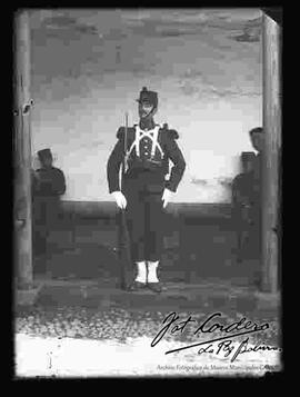 Soldado con uniforme frances, sosteniendo un fusil, en la puerta de un cuartel