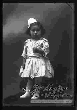 Foto de estudio de una niña pequeña parada sobre un sillón