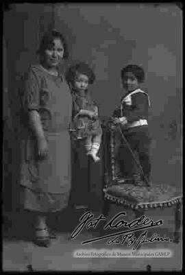 Foto de estudio de una familia, dama junto a sus dos hijos