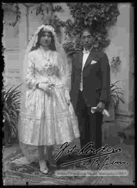 Una pareja de novios, en el patio de una casa. chola vestida de blanco con su esposo