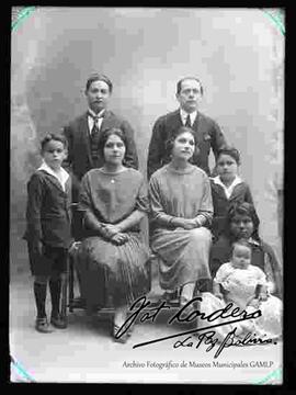 Foto de estudio de una familia junto a su empleada, una niña de pollera