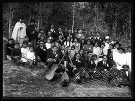 Grupo familiar en un día de campo, con un conjunto musical de estudiantina