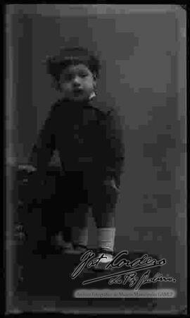 Foto de estudio de un niño pequeño, parado encima de un sillón