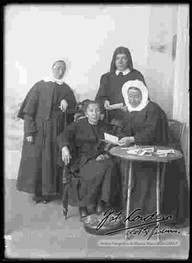 Monjas observando fotos tridimensionales junto a una anciana