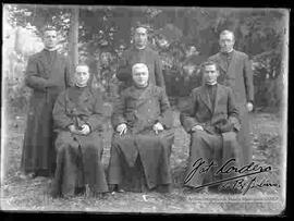 Grupo de seis sacerdotes, en un jardín