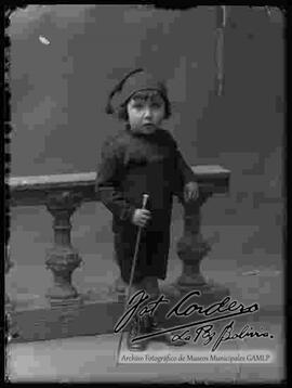 Foto de estudio de un niño que se encuentra parado delante de un barandal