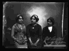 Foto de estudio de tres señoritas que presentan un peinado con wincha.