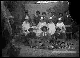 Familia reunida en el patio de una casa, celebrando carnavales con música.