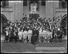 Grupo de estudiantes del colegio San Calixto, en el día de su primera comunión, junto a un obispo en las gradas del colegio.