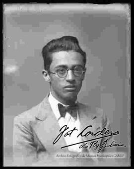 Foto de estudio de medio cuerpo de un varón vestido de traje, corbata y lentes
